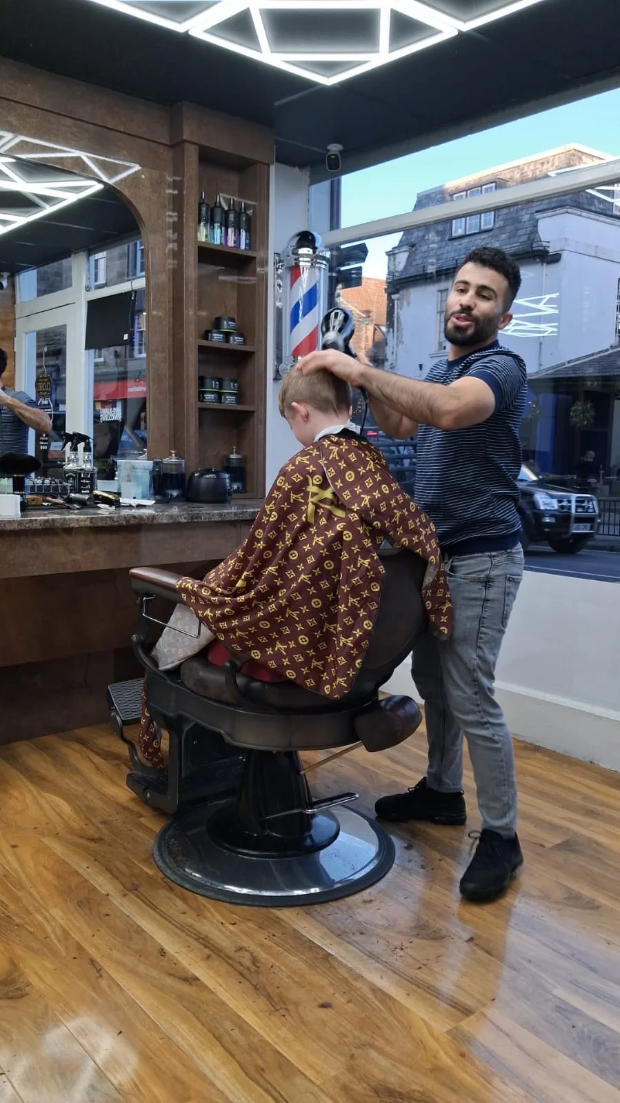 A Cutting Crew barber at work beside the Kirkgate shop window