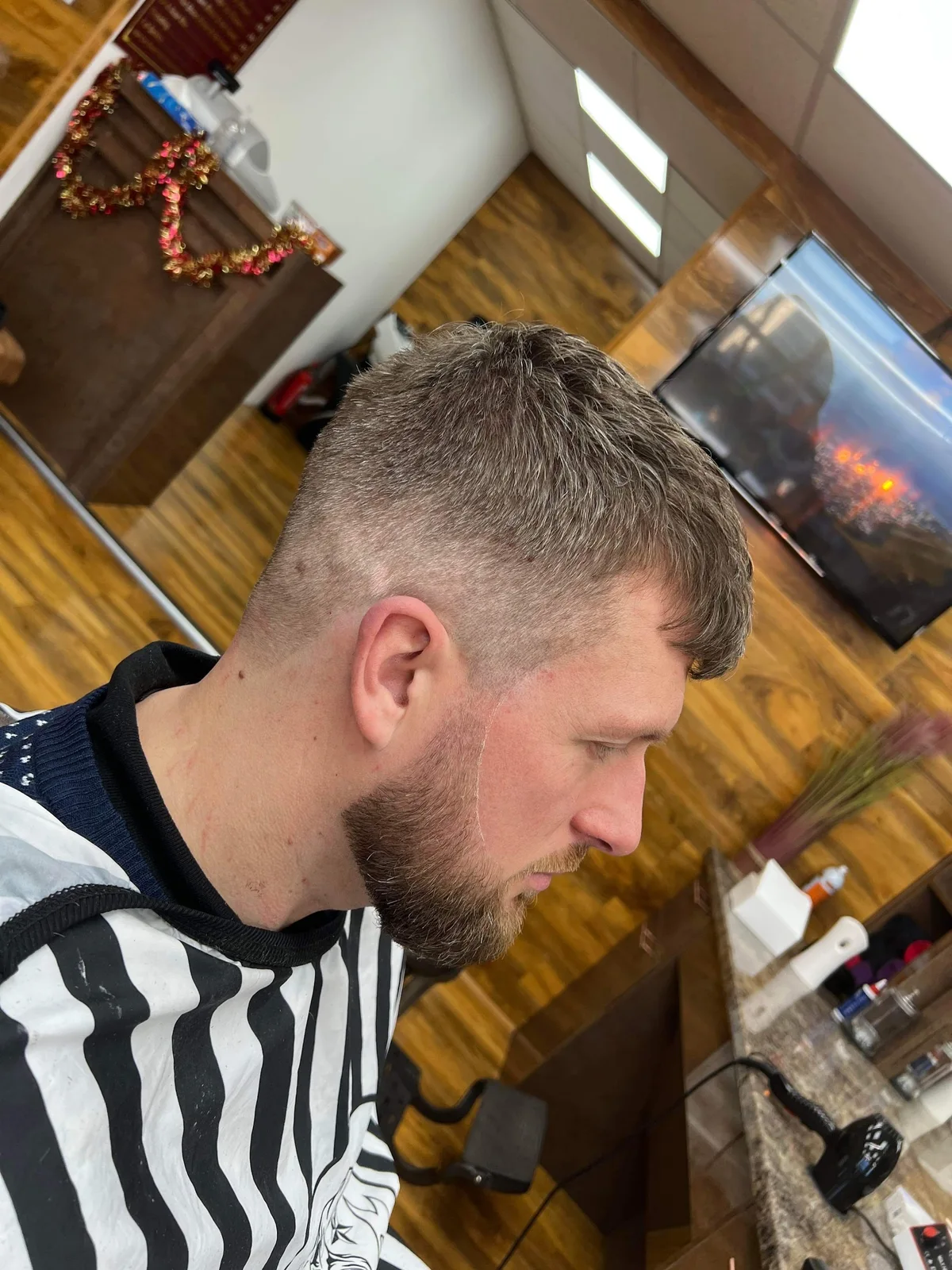 A finished haircut and shaped beard in the wood-panelled Cutting Crew shop